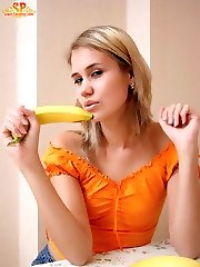 Captivating lass is sitting on the table in sexy panties and is going to pet her fabulous pussy with yellow appetizing bananas.